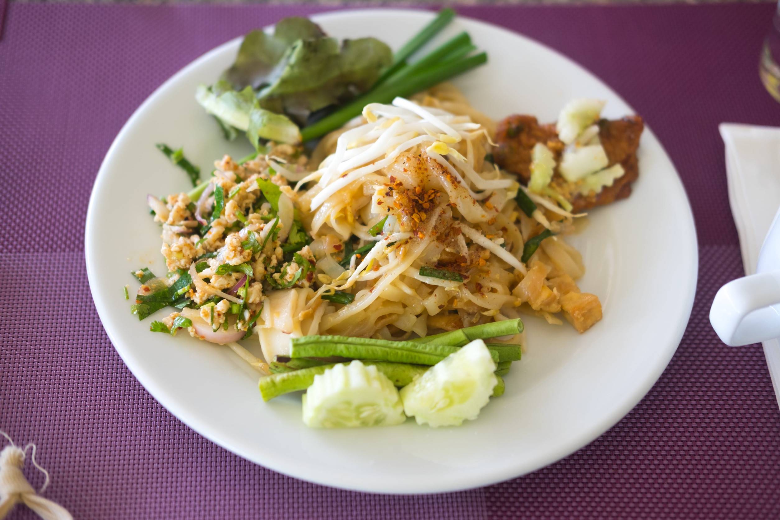 Thai Cuisine On A White Plate With Napkins On Its Side